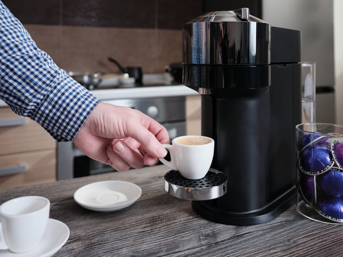 Caja de cápsulas McCafé Premium Roast K-Cup con etiqueta de descafeinado pero que contienen cafeína, junto a taza de café humeante