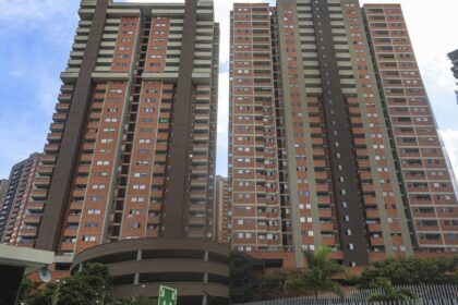 Familia revisando documentos de vivienda VIS con preocupación por el alza del 23% en el salario mínimo que encarece su cuota mensual