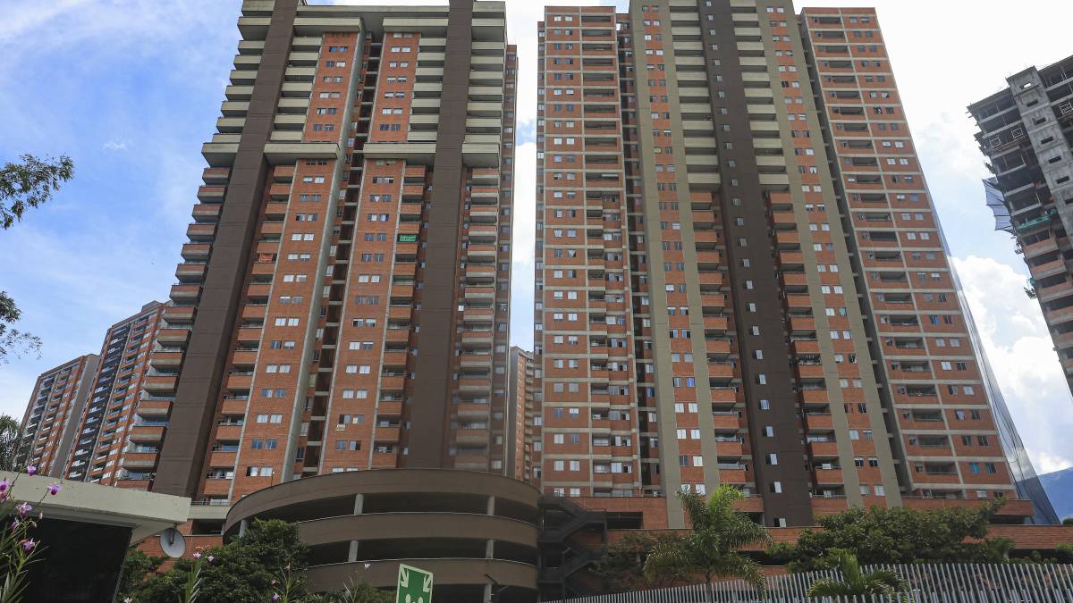 Familia revisando documentos de vivienda VIS con preocupación por el alza del 23% en el salario mínimo que encarece su cuota mensual