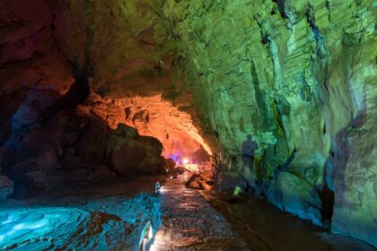 Interior de una casa tallada en roca con pozas naturales de agua cristalina y luz solar filtrándose entre las paredes de piedra