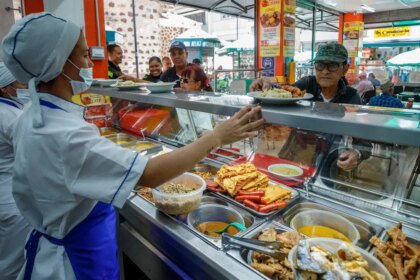 Familia revisando facturas con calculadora para ajustar gastos tras alzas en cuotas de administración y servicios en 2026
