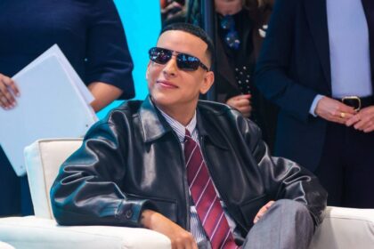 Daddy Yankee y Olga Tañón sonriendo frente al logo de la campaña turística 'Yo Te Quiero Puerto Rico' en Fitur 2026