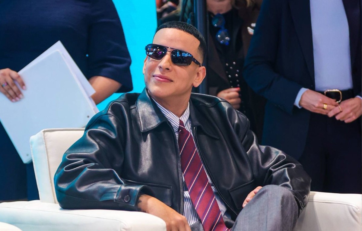 Daddy Yankee y Olga Tañón sonriendo frente al logo de la campaña turística 'Yo Te Quiero Puerto Rico' en Fitur 2026