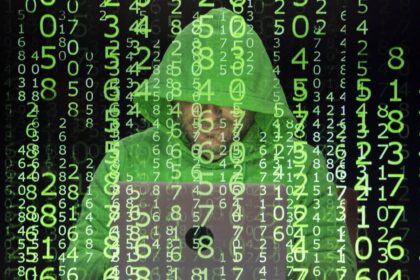 Persona revisando correo sospechoso de Booking falso con alerta de fraude digital y voz clonada en pantalla de computador