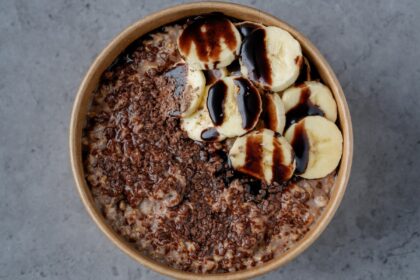 Bowl de porridge de avena con cacao, pistachos triturados y frambuesas frescas, preparado para combatir la inflamación en minutos