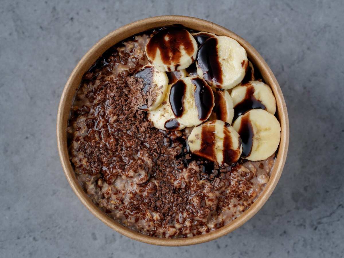 Bowl de porridge de avena con cacao, pistachos triturados y frambuesas frescas, preparado para combatir la inflamación en minutos