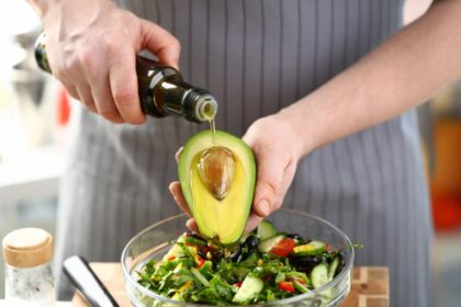 Aguacate fresco en recipiente hermético con limón y hojas verdes en papel absorbente para evitar humedad y prolongar frescura