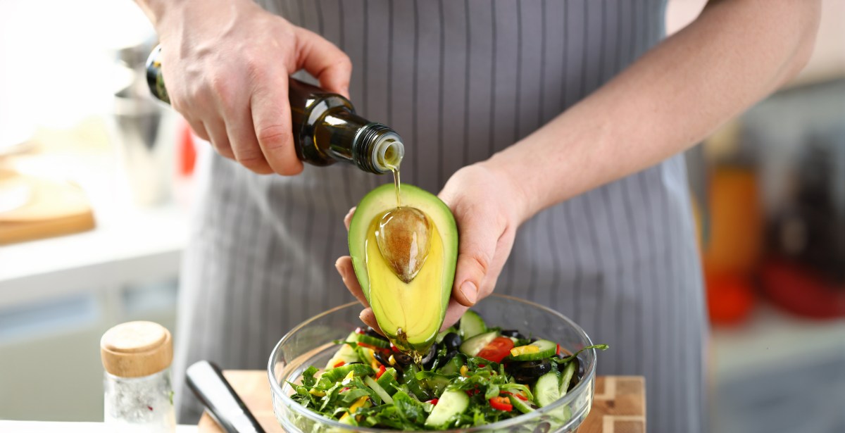 Aguacate fresco en recipiente hermético con limón y hojas verdes en papel absorbente para evitar humedad y prolongar frescura
