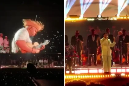 Bad Bunny en el escenario de Medellín tocando la guitarra mientras el público enciende linternas en homenaje a Yeison Jiménez