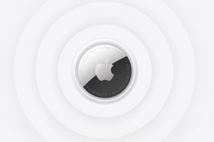AirTag 2 negro junto a un iPhone mostrando la Búsqueda de Precisión con flechas y distancia exacta para encontrar llaves o maletas