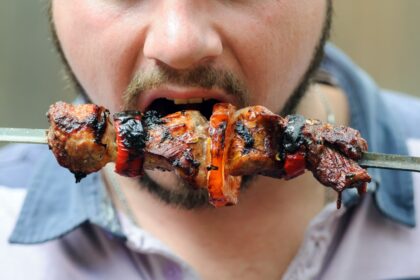 Corte de carne de res cruda junto a gráficos científicos que muestran la relación entre su consumo y el riesgo de cáncer colorrectal según estudios de Harald zur Hausen