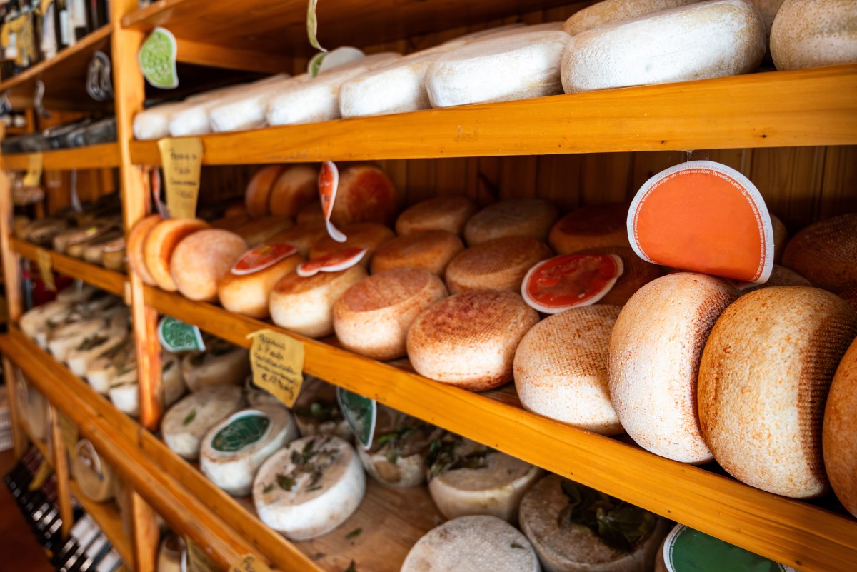 Queso pecorino rallado en bolsa con etiqueta de lote afectado por alerta de listeria de la FDA, fondo de refrigerador con advertencia de riesgo