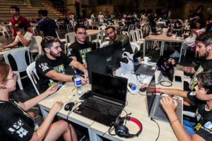 Equipo de desarrolladores trabajando en un prototipo de videojuego durante el Global Game Jam, con pantallas mostrando código y diseños en tiempo real