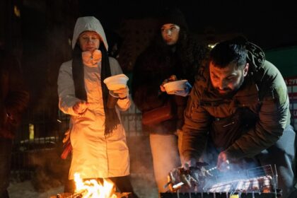 Trabajadores reparando cables eléctricos cubiertos de hielo en Troyeshina, Kiev, durante la crisis por ataques rusos a la red energética