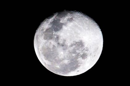 Luna llena iluminando un paisaje invernal con lobos aullando bajo un cielo estrellado, en la primera superluna de 2026
