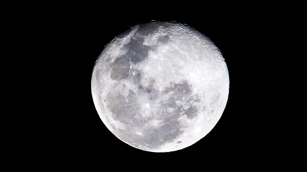 Luna llena iluminando un paisaje invernal con lobos aullando bajo un cielo estrellado, en la primera superluna de 2026