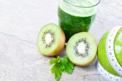 Vaso de jugo verde fresco con espinacas, kiwi y manzana verde, ingredientes clave para estimular colágeno natural y salud digestiva