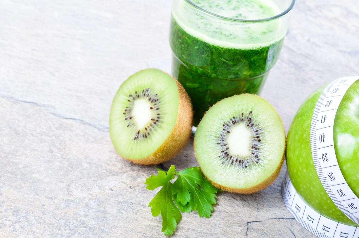Vaso de jugo verde fresco con espinacas, kiwi y manzana verde, ingredientes clave para estimular colágeno natural y salud digestiva
