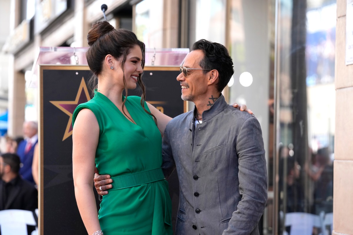 Pareja sonriente mostrando la barriga de embarazo junto a su primer hijo Max en un momento familiar íntimo
