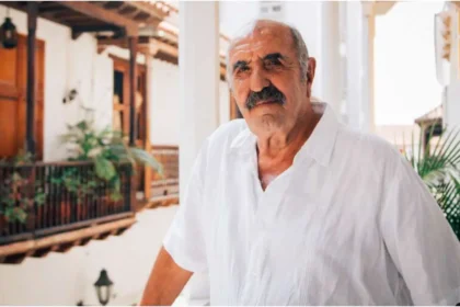 Retrato de Salvo Basile sonriendo en Cartagena, con sombrero vueltiao y camisa blanca, rodeado de niños de su fundación