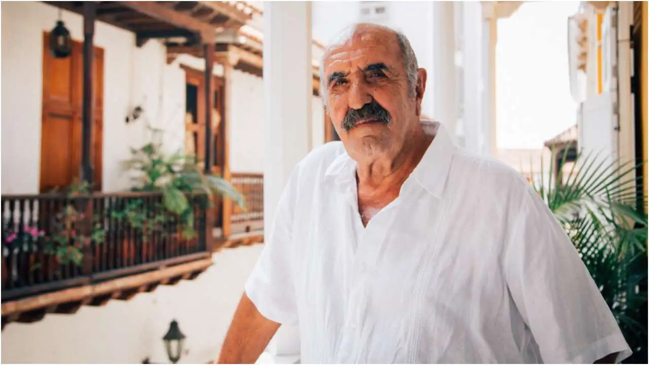 Retrato de Salvo Basile sonriendo en Cartagena, con sombrero vueltiao y camisa blanca, rodeado de niños de su fundación