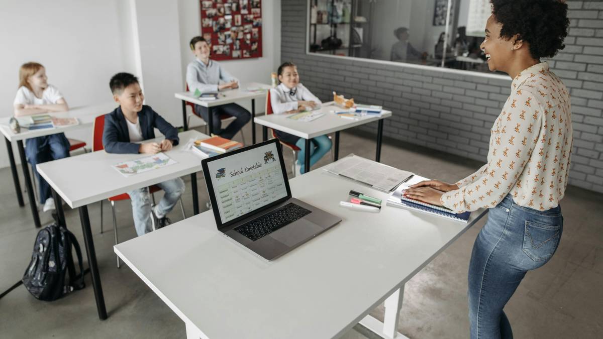 Profesora usando ChatGPT en una tablet para planificar clases innovadoras con inteligencia artificial en el aula