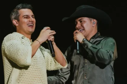 Pipe Bueno y Yeison Jiménez en tarima, compartiendo un abrazo fraternal durante un concierto de música popular colombiana