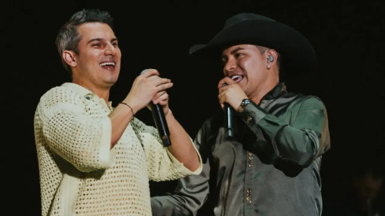 Pipe Bueno y Yeison Jiménez en tarima, compartiendo un abrazo fraternal durante un concierto de música popular colombiana