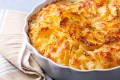 Papa Russet horneada rellena de puré cremoso con sopa condensada de pollo, hierbas frescas y queso gratinado en fuente de cocina