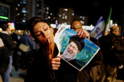 Manifestante iraní quemando imagen del ayatolá Khamenei durante protestas masivas contra el régimen teocrático en crisis