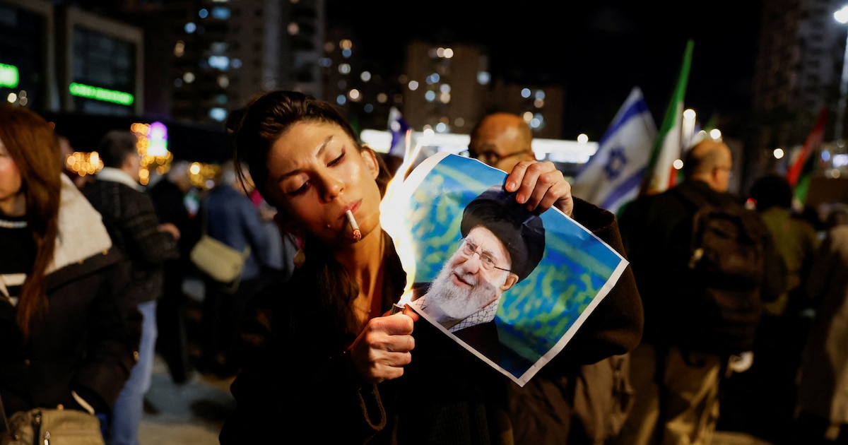 Manifestante iraní quemando imagen del ayatolá Khamenei durante protestas masivas contra el régimen teocrático en crisis