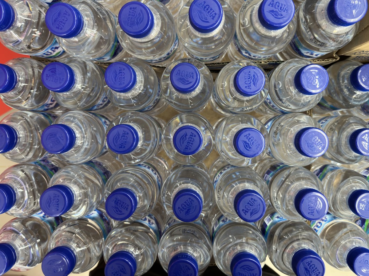 Jarra de agua destilada con tapa roja mostrando partículas negras en el fondo, señal de contaminación por filtros dañados o moho