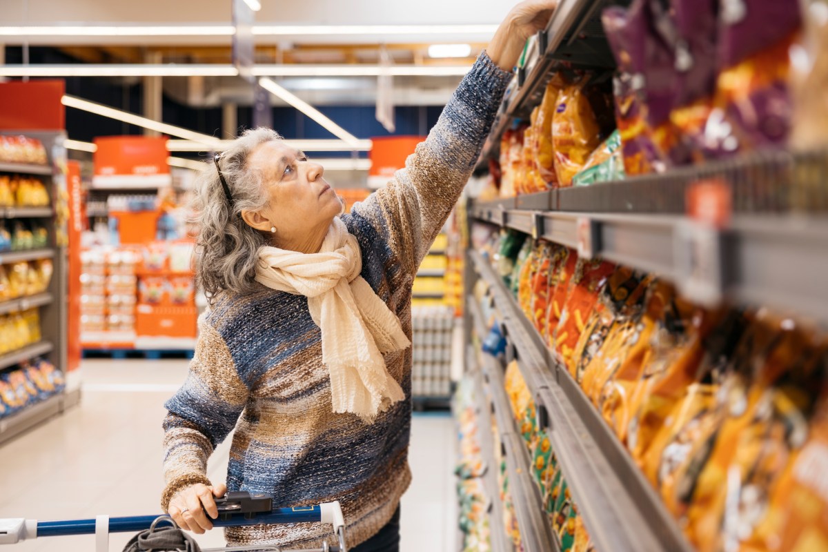Cajas de cereales Cheerios, latas de Coca-Cola y paquetes de Pringles apilados con advertencia de contaminación por roedores en almacén