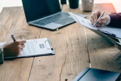 Mujer revisando contrato de 36 horas semanales con salario inferior a $2 millones en una oficina con calculadora y documentos legales