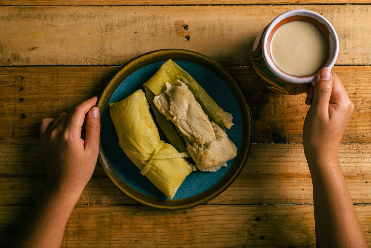 Masa de maíz tierno recién molida en hojas verdes de elote, lista para envolver tamales tradicionales al vapor
