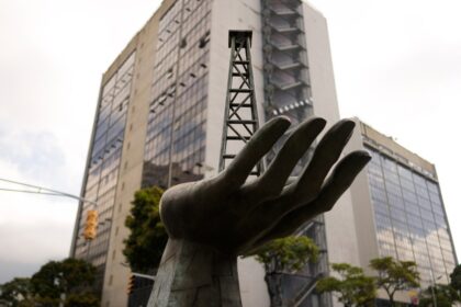 Tanques de almacenamiento de petróleo venezolano con gráficos de dólares y bolívares superpuestos, reflejando el impacto del acuerdo de $300 millones