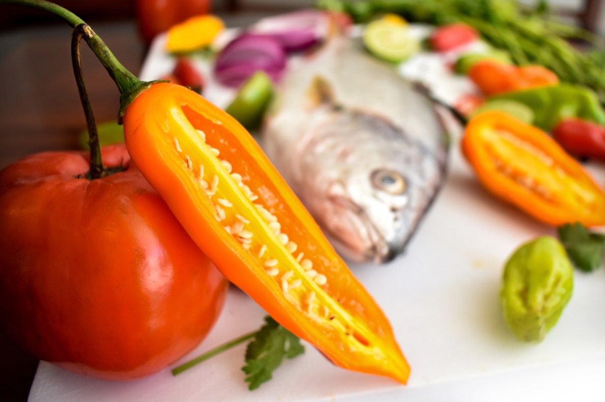 Plato con verduras frescas y pescado al horno, fuente de antioxidantes y Omega-3 para una vida más larga y saludable