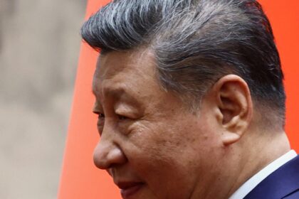 Xi Jinping en un discurso oficial con gráficos de 983.000 sanciones por corrupción en 2023, reflejando el control absoluto del Partido Comunista
