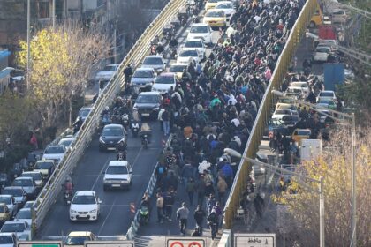 Manifestantes cruzando un puente en Teherán durante protestas masivas contra la crisis económica y el régimen de Jamenei en 2025