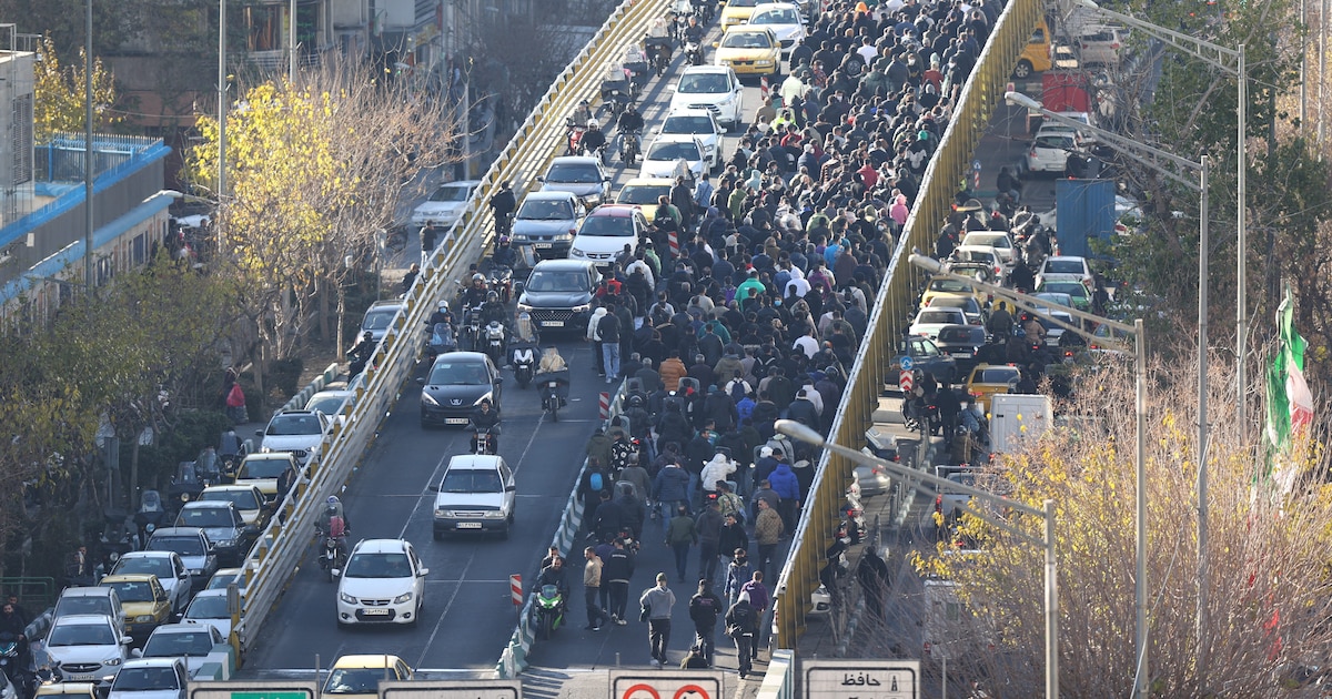 Manifestantes cruzando un puente en Teherán durante protestas masivas contra la crisis económica y el régimen de Jamenei en 2025