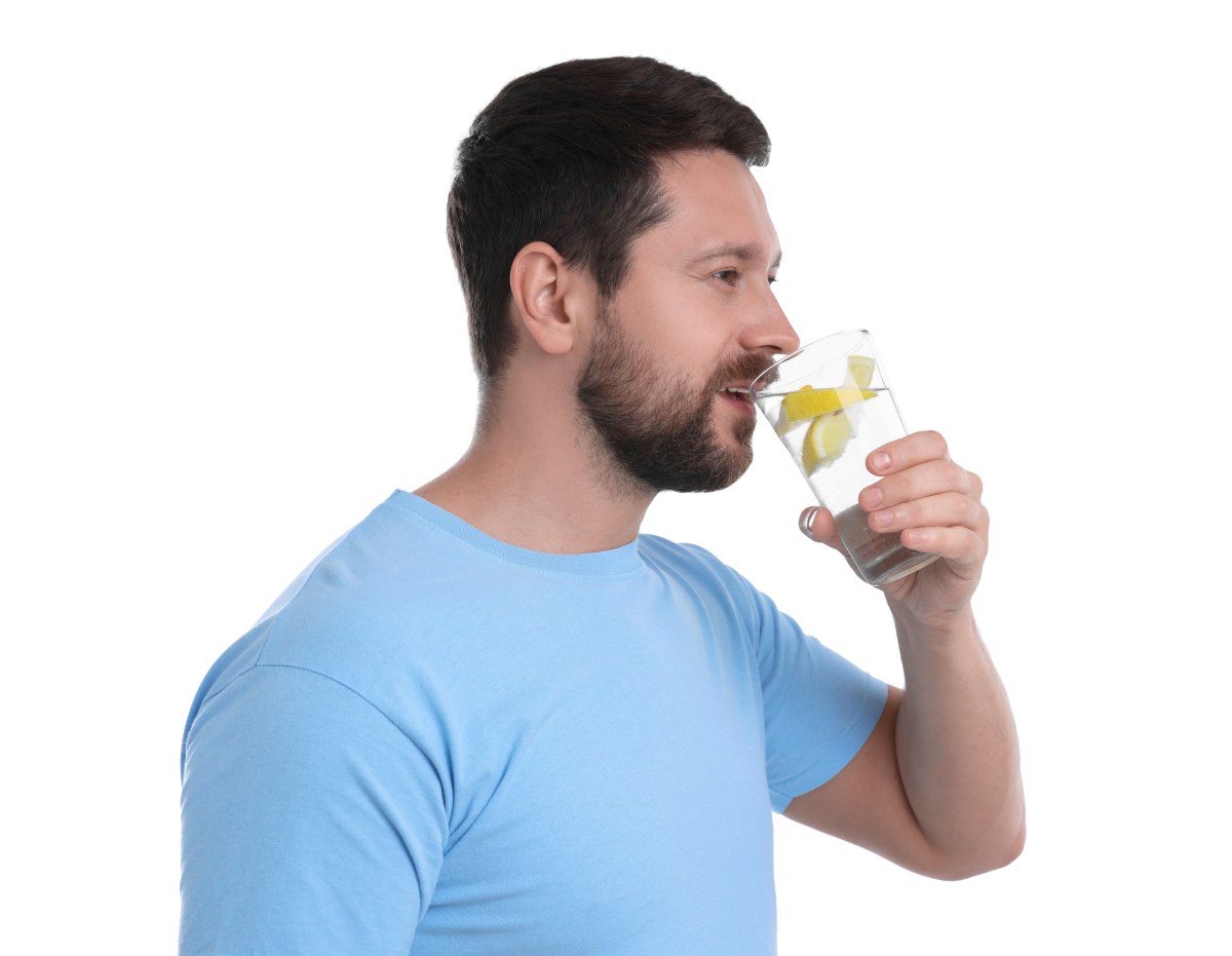 Vaso de agua con limón y sal marina sobre mesa de madera, simbolizando hidratación efectiva con minerales esenciales