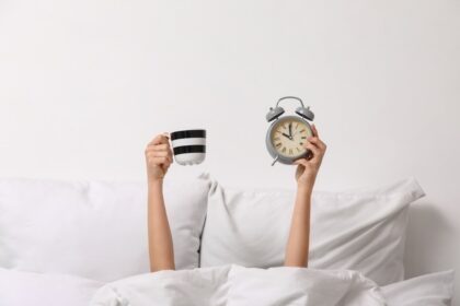 Taza de café recién hecho junto a un reloj despertador marcando 60 minutos, simbolizando el tiempo óptimo para tomar café según la ciencia