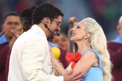Lady Gaga con vestido azul eléctrico y flor de maga junto a Bad Bunny en un escenario vibrante de salsa durante el Super Bowl 2026