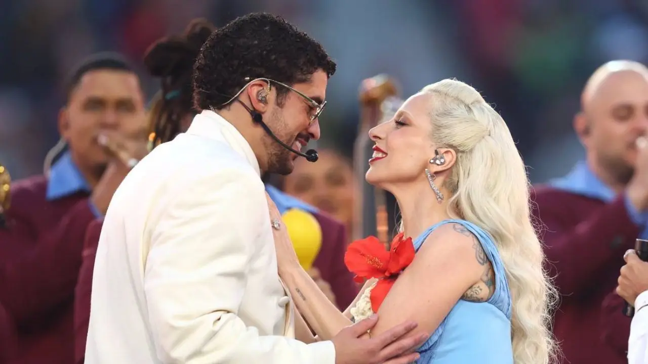 Lady Gaga con vestido azul eléctrico y flor de maga junto a Bad Bunny en un escenario vibrante de salsa durante el Super Bowl 2026
