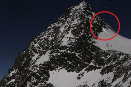 Montañista con equipo de escalada en la cumbre del Grossglockner bajo tormenta de nieve, reflejando el debate sobre negligencia en alpinismo
