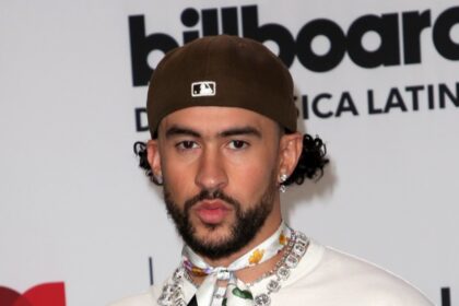 Bad Bunny en el escenario con la bandera de Puerto Rico, simbolizando su conexión con las raíces latinas y su influencia global en la música