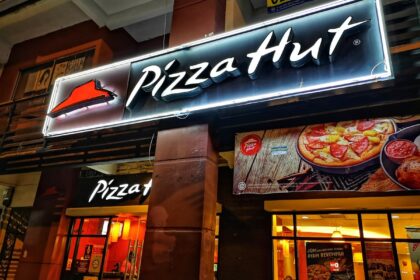 Exterior de un local de pizza con letrero apagado, simbolizando el cierre de 250 restaurantes en EE.UU. como parte del plan 'Hut Forward'