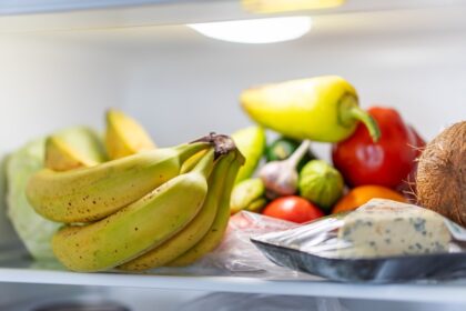Frutas y verduras frescas en recipientes de vidrio dentro de un refrigerador bien organizado para maximizar su durabilidad