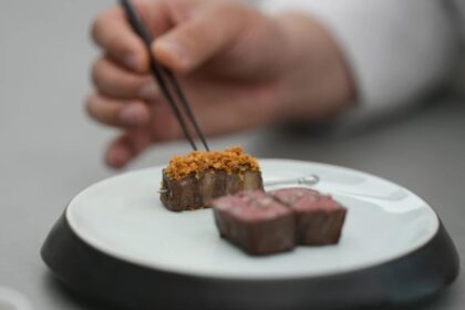 Chef Jun Lee preparando su plato estrella Hanwoo y Banchans en SOIGNÉ, restaurante de alta cocina coreana en Seúl