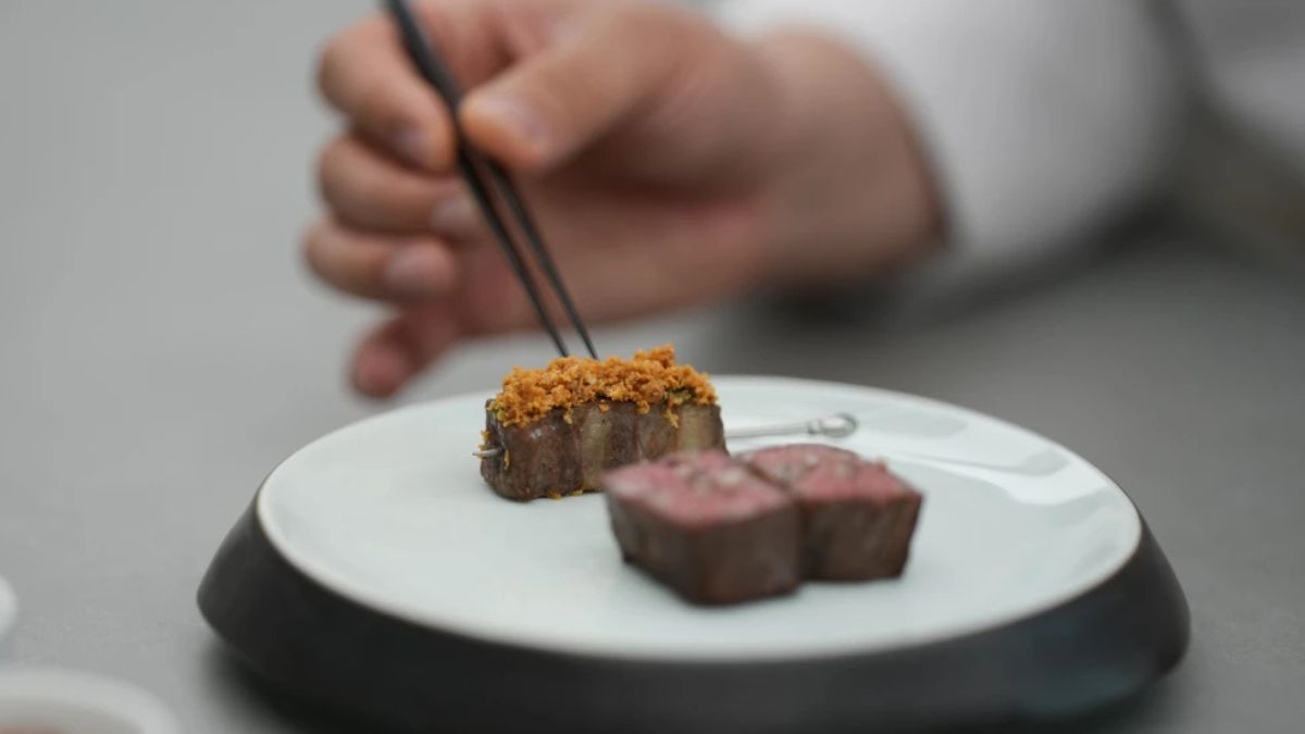 Chef Jun Lee preparando su plato estrella Hanwoo y Banchans en SOIGNÉ, restaurante de alta cocina coreana en Seúl